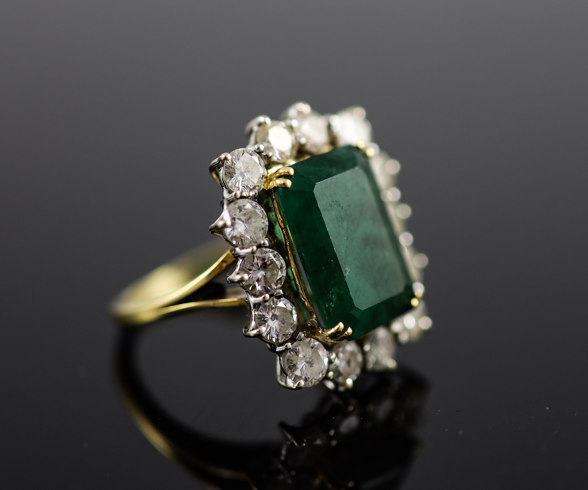 A mid to late 20th century 18ct gold, emerald and diamond set shaped rectangular cluster ring